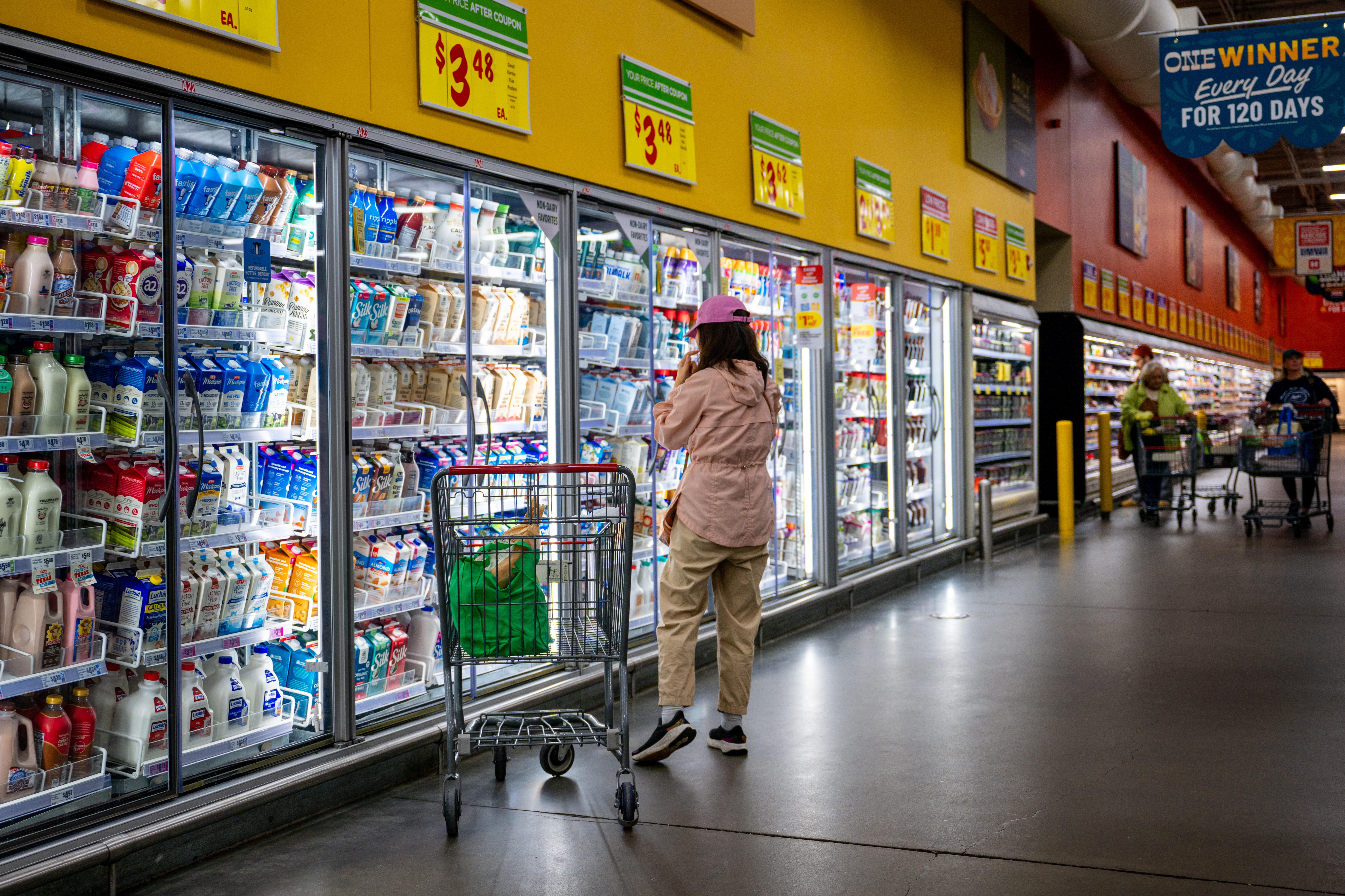 A customer shops for produce at an H-E-B grocery store earlier this year in Austin, Texas. Many shoppers are cutting back on purchases due to higher costs.